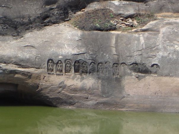 Detailed carvings on the rock face behind the pond at Arattipura, India.